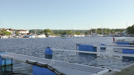 View-From-Harbour-Of-A-Boat-Sailing-Across-Fjord-In-Kragero,-Norway