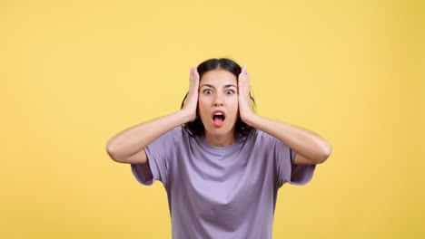 shocked woman expressing fear on yellow background