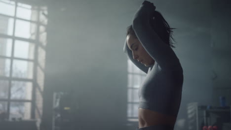 woman standing in sport club. fitness girl fixing ponytail before training