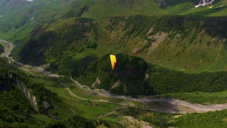 chasing drone shot of people paragliding in the caucasus mountains in gudauri georgia