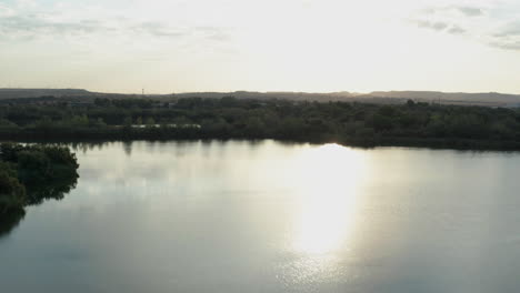 laguna el picon de los conejos near madrid in spain. sun reflection on water. aerial drone shot.