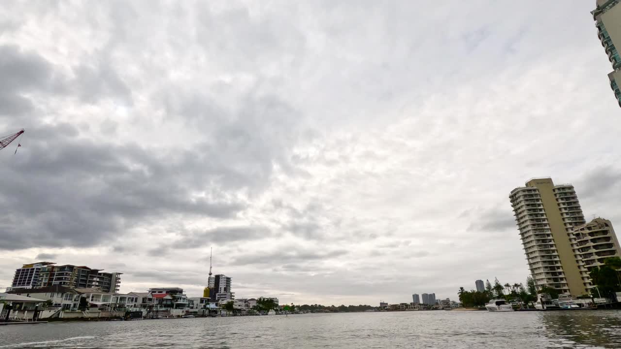 구름이 가득한 하늘 아래의 마천루와 운하