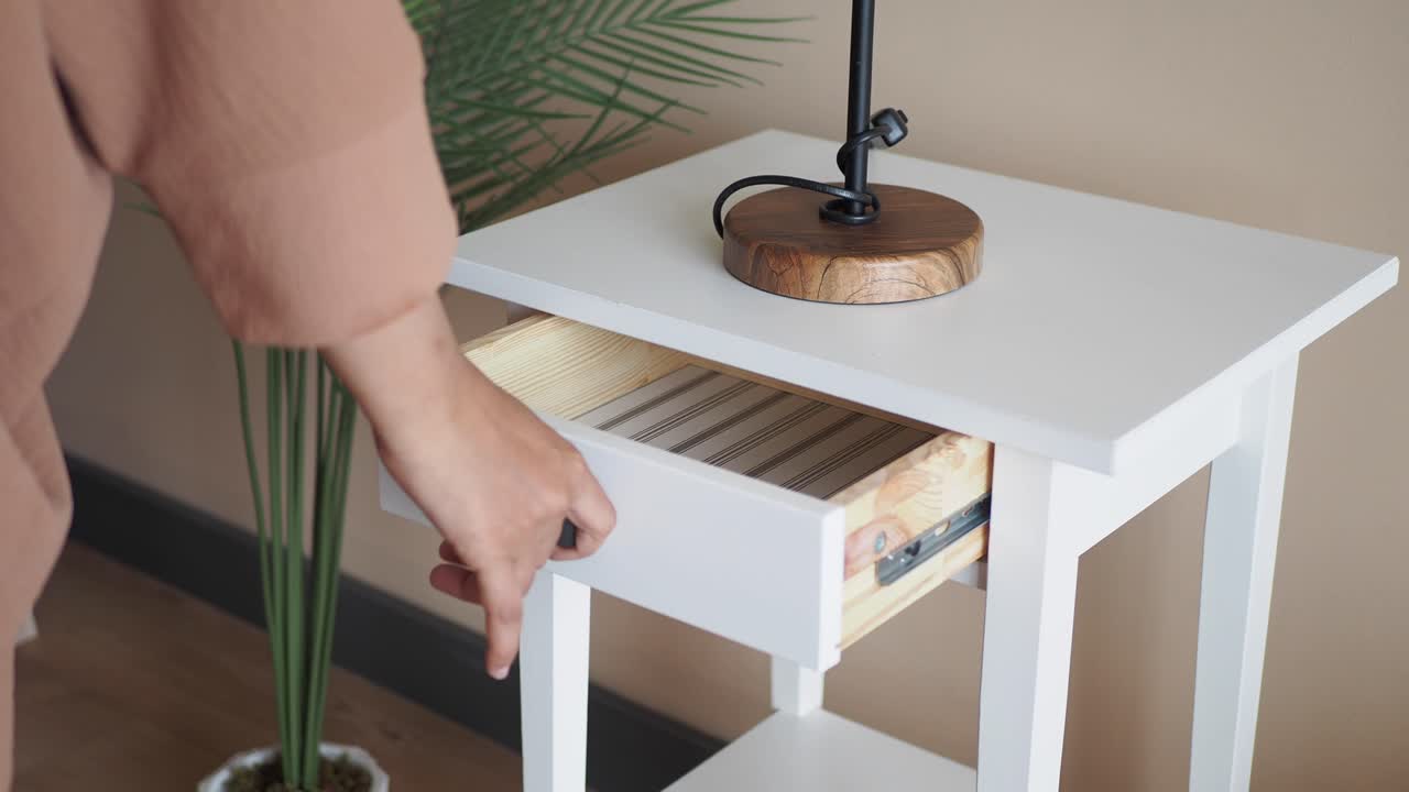 mesa de noche blanca con tapa de madera y lámpara negra