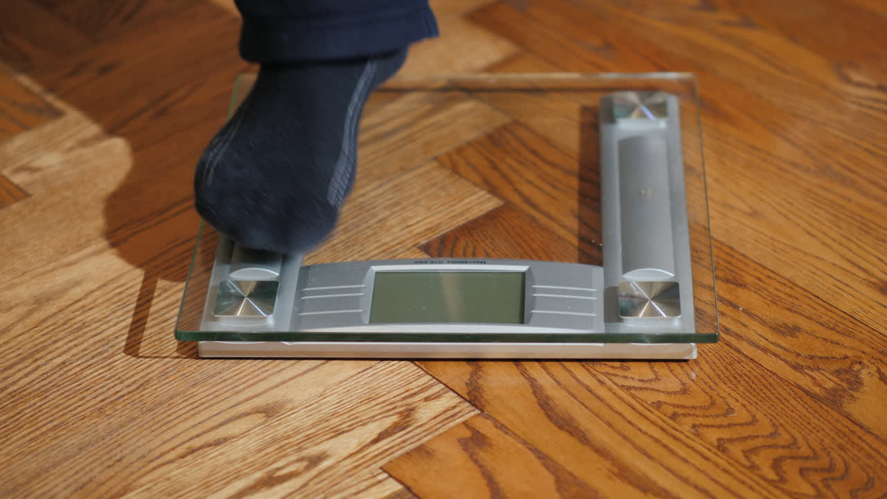 el hombre se pesa en básculas de piso 01