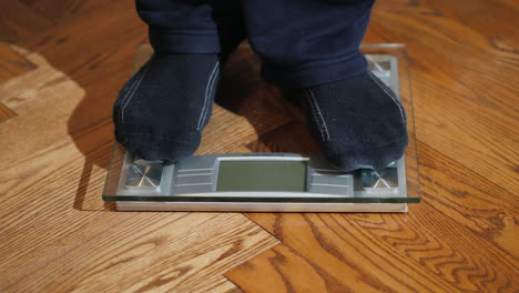 Man-Weighs-Himself-On-Floor-Scales-01