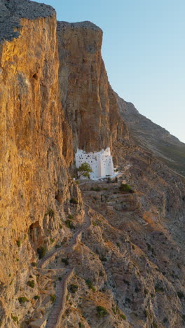 aerial view of holy monastery of virgin mary chozoviotissa, built into dramatic cliffside, greece. vertical