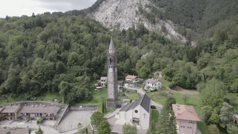 video con drone de plano orbital y espiral en la torre con reloj de la iglesia del pueblo pûstal de italia