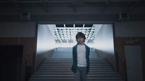 Sad-boy-walking-empty-school-hall.-Teen-child-going-on-futuristic-stairway.