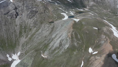 aerial reveal of thawing snow on high mountain top