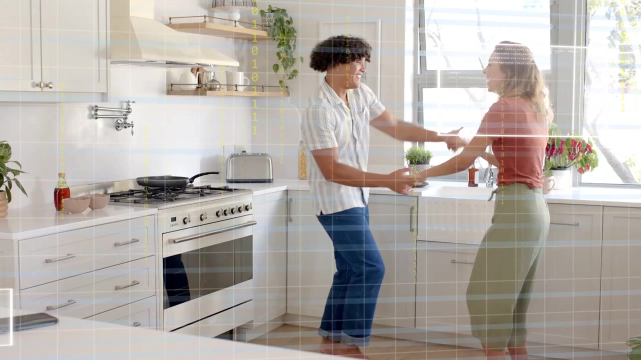 Man and woman taking hands in bright home kitchen, spinning and guiding loving dance near stove