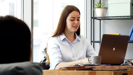 hermosa mujer de negocios alegre hablando con su colega en el trabajo
