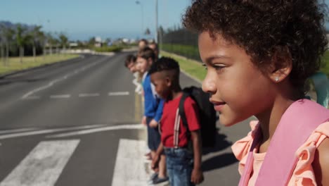 group of kids looking for traffic before crossing the road