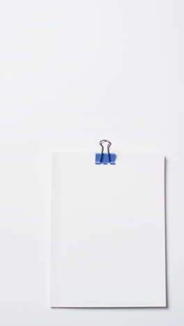 video of books with white blank pages and blue paper clip with copy space on white background