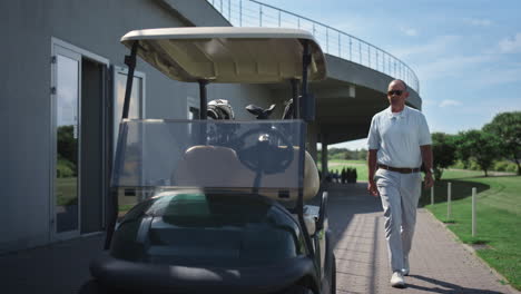 un rico jugador de golf caminando en un carrito de conducción, un anciano de lujo sentado en un club de campo.