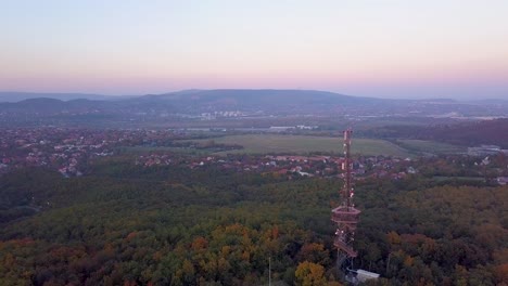 volando por una torre de vigilancia con una torre de telecomunicaciones montada encima de ella en un bosque en hungría