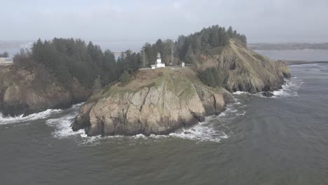 cape disappointment lighthouse sits high above the churning pacific ocean waves, aerial orbit