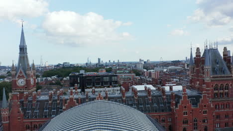 Backwards-reveal-of-beautiful-historic-front-building-of-St-Pancras-train-station.-Red-brick-clock-tower-in-castle-style.-London,-UK