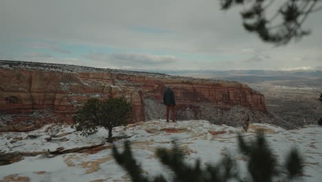 Hombre-Corriendo-En-Un-Cañón-Cubierto-De-Nieve-Disfrutando-Del-Hermoso-Paisaje