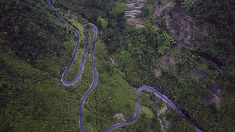 moody aerial shot of a curvy road in a mountainous area on a gloomy day