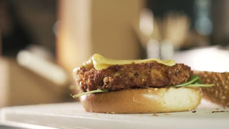 close-up of chef hands wearing black glove adds cheese on beef burger. slow-motion