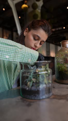 woman gardening with succulents in a terrarium