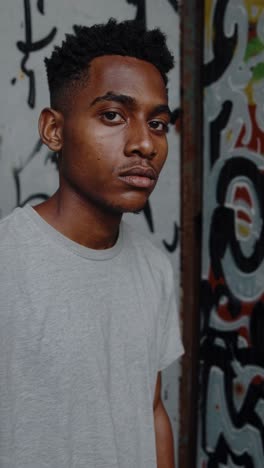 young man in front of graffiti wall