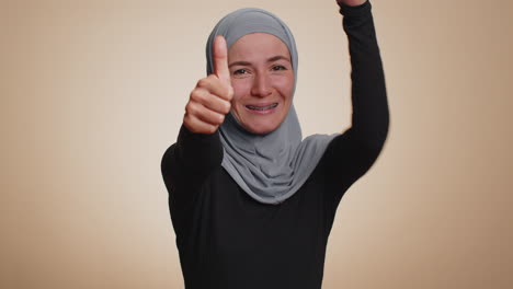 hipster woman raises thumbs up agrees or gives positive reply recommends advertisement likes good