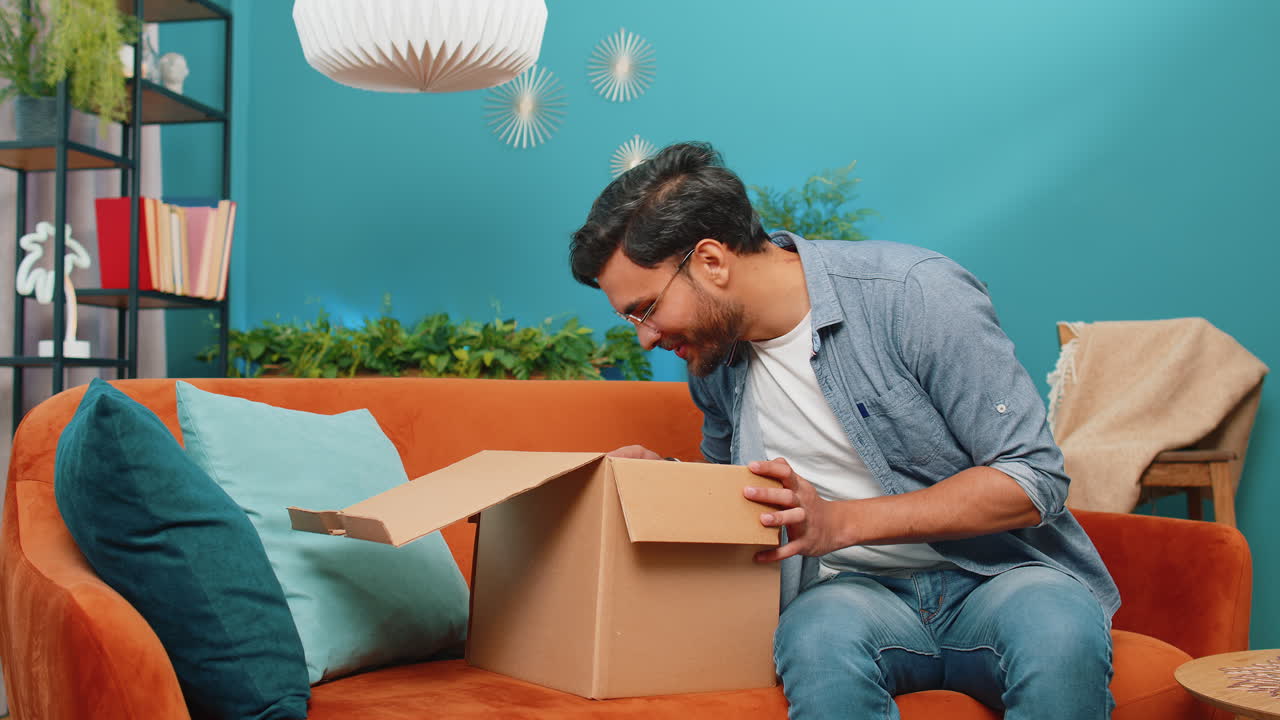 feliz hombre árabe comprador desempaque caja de cartón entrega paquete compras en línea compra en casa