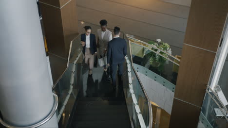 business people walking upstairs in modern office