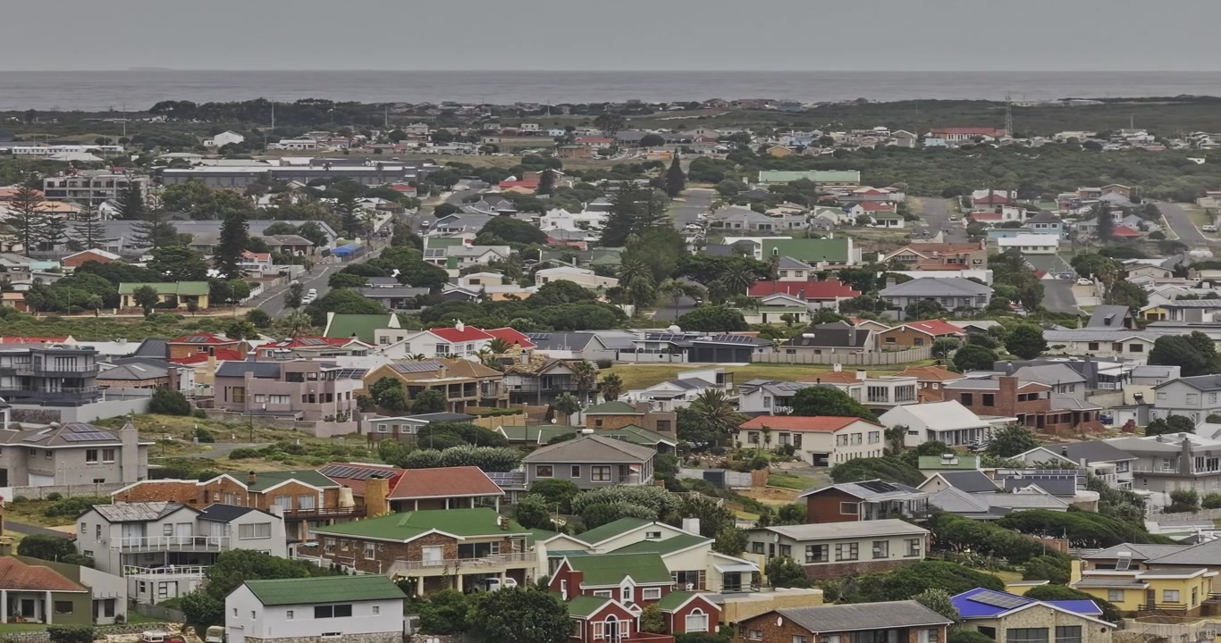 Gansbaai, Sudafrica. Aerea v5, sorvolo basso con teleobiettivo lungo su residenze costiere e denso paesaggio urbano costiero - Scattato con Mavic 3 Pro Cine - 7 gennaio 2024.