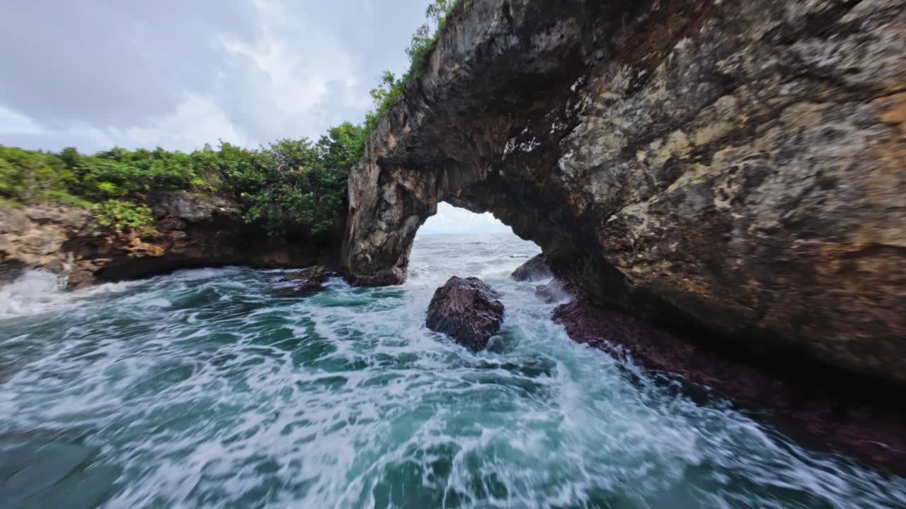 Epic FPV Dive Through the Rock Arch at La Hondonada, Samaná, Capturing Crashing Waves and Vibrant Ocean Scenery on a Perfectly Sunny Day