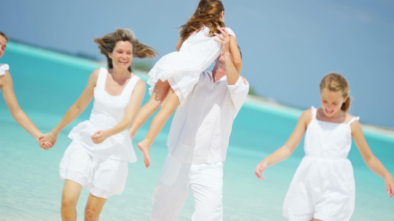 백인 부모 와 그 들 의 여자 자녀 들 이 해변 을 즐기고 있다