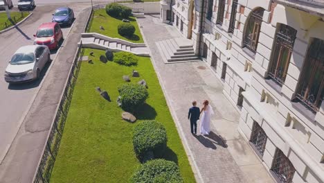 bride-spins-walking-with-groom-in-street-aerial-view