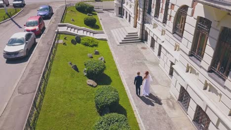 bride spins walking with groom in street aerial view