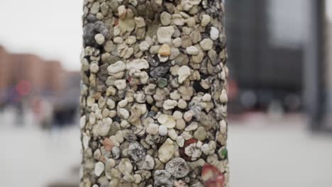 Pillar-covered-with-artistic-mosaic-of-tiny-different-stones-and-pebbles,-close-up