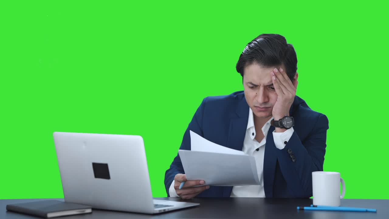 gerente indio tenso leyendo y firmando informes pantalla verde