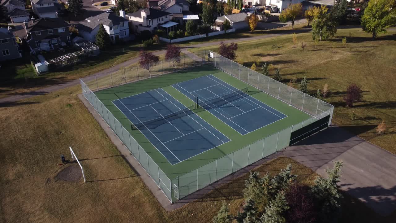 Neighbourhood Tennis court approached aerial drone autumn fall