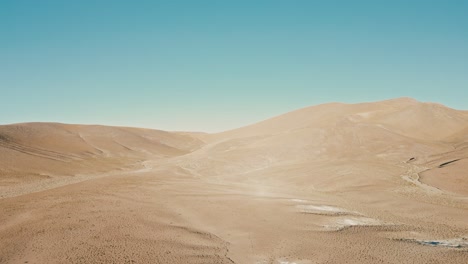 Drone-footage-captures-the-stark,-otherworldly-beauty-of-the-Atacama-Desert,-revealing-its-rugged,-barren-terrain-from-a-unique-aerial-perspective