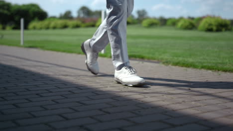 golf man legs walking at course. luxury man going at summer golfing country club