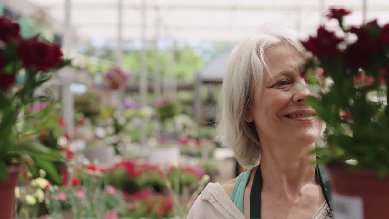 Woman working in a garden center surrounded by flowers