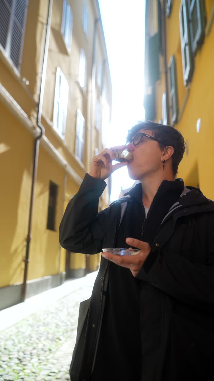 Persona che si gode un caffè e un dolce in una strada di città europea