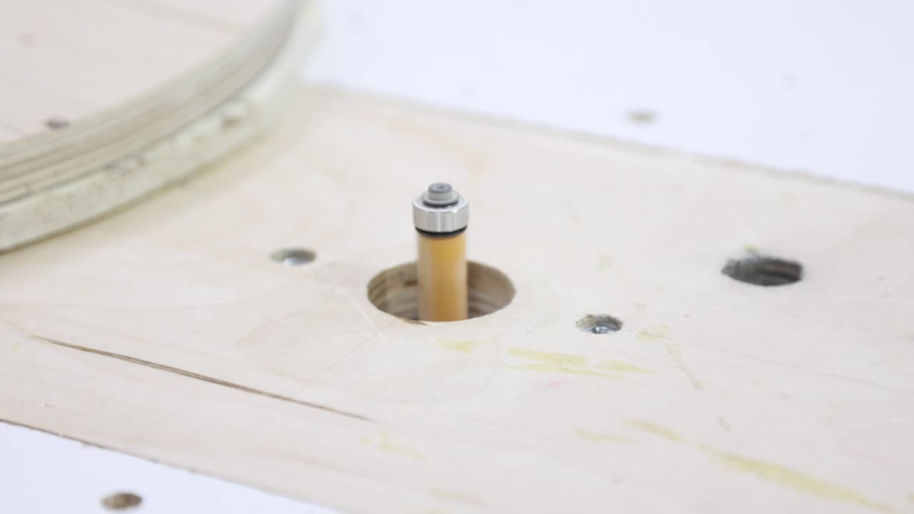 작업자는 템플릿에 따라 플라이우드 끝을 아줍니다. 가구 생산