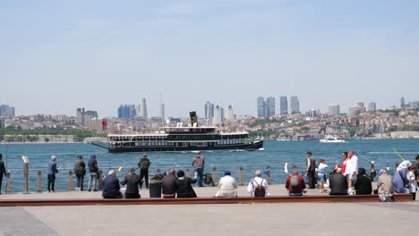 people fishing at the istanbul pier with city skyline view