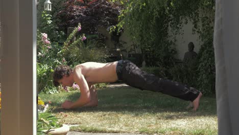 A-young-man-performing-a-Spinx-Variation-pushup