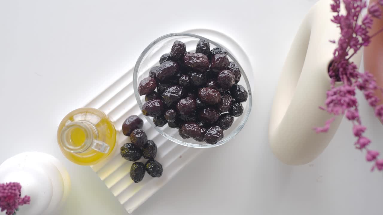 aceitunas negras en un cuenco de vidrio con aceite de oliva