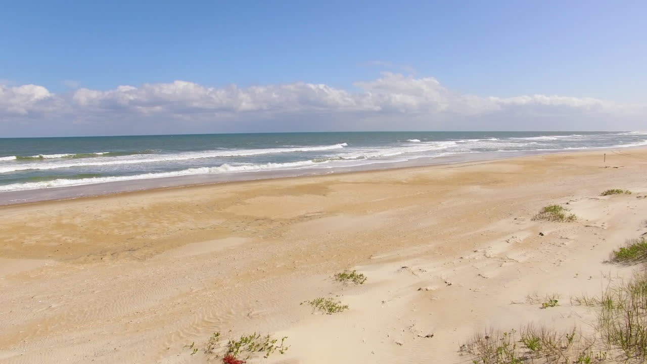 모래 언덕 위의 빈 해변의 드론 영상
