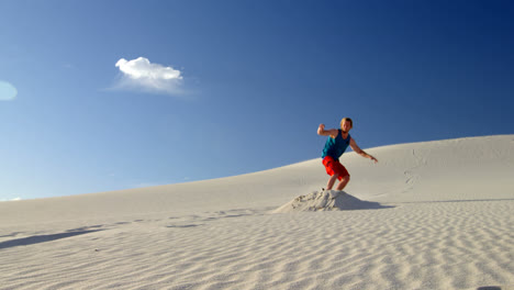 Man-performing-a-jump-while-sand-boarding-4k