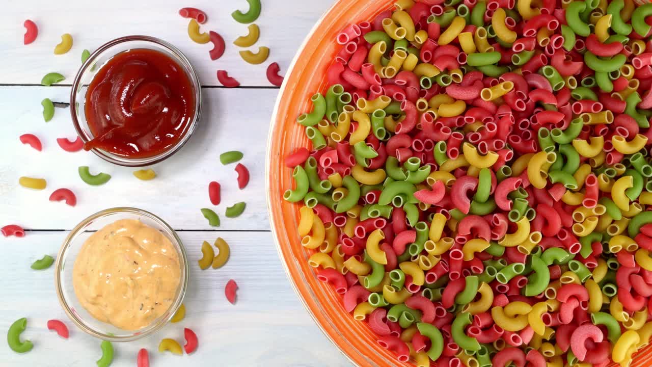 다채로운 익히지 않은 원시 이탈리아 파이프 파스타가 접시에서 회전 테이블에서 천천히 회전합니다.