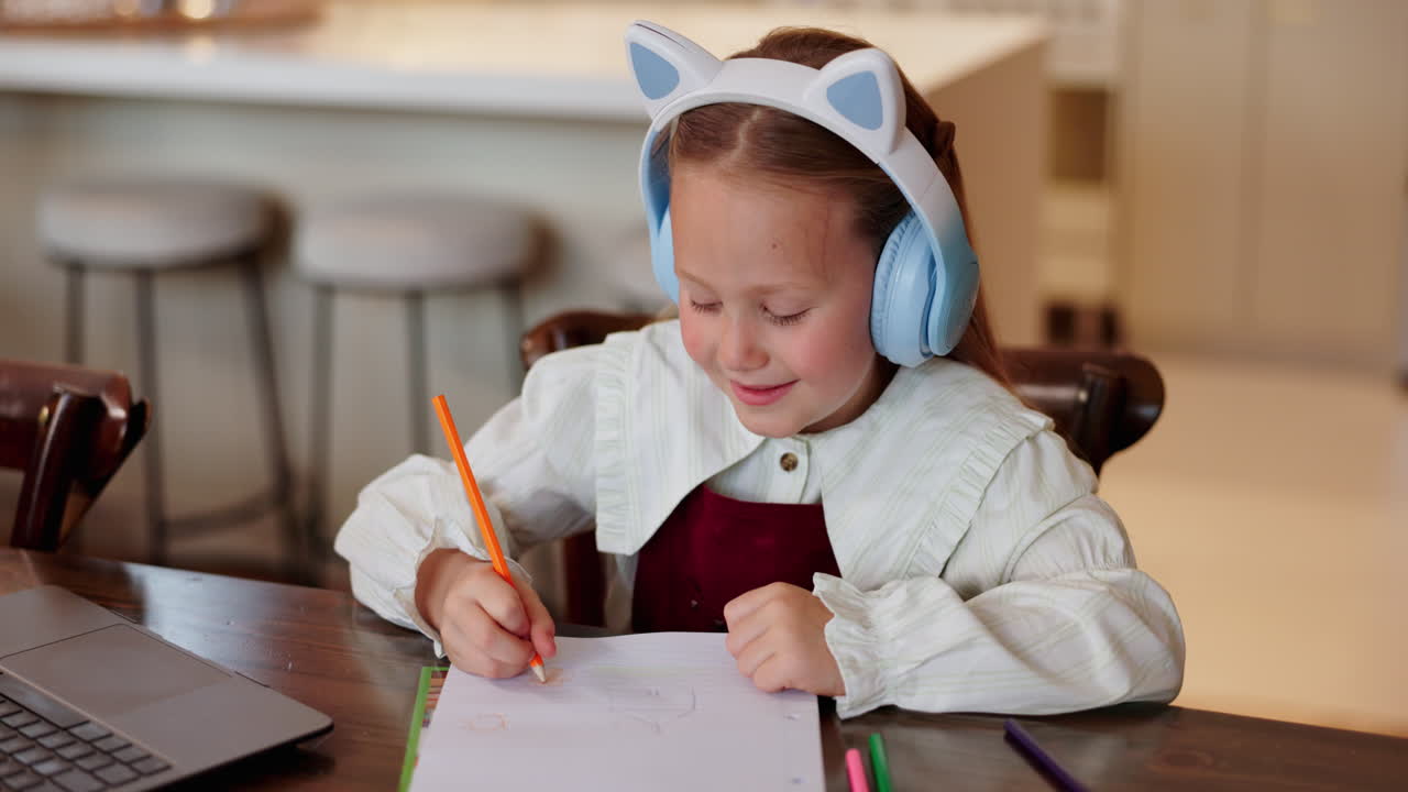 девушка рисует дома с наушниками