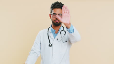 Doctor-man-say-no-hold-palm-folded-crossed-hands-in-stop-gesture-warning-of-finish-prohibited-access